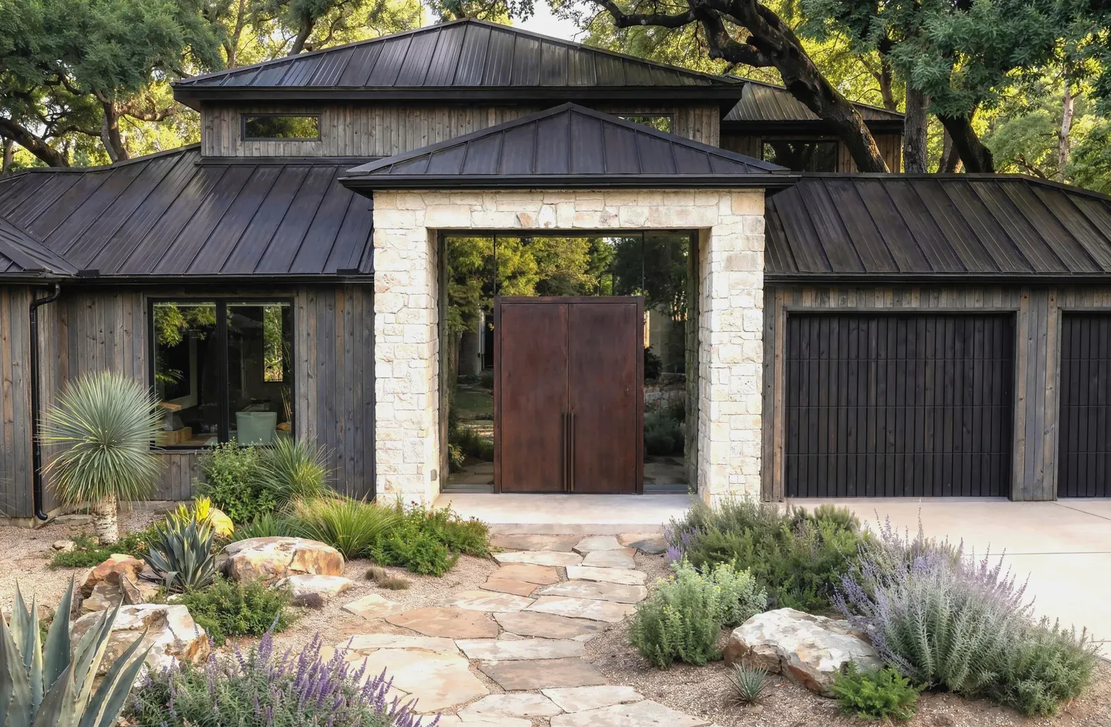 House re-skinned in weathered silver-gray wood with black standing-seam metal and Corten steel entry doors